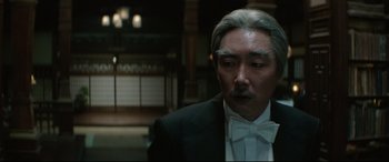 Movie still from “The Handmaiden” (2016), directed by Park Chan-wook – An older man wearing a tuxedo and a bow tie; Close Up shot, Over the shoulder angle