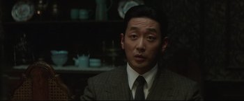 Movie still from “The Handmaiden” (2016), directed by Park Chan-wook – A person wearing a suit and tie; Close Up shot, Over the shoulder angle