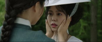 Movie still from “The Handmaiden” (2016), directed by Park Chan-wook – A young woman with her hands on her face and another woman with her hands on her face; Close Up shot, Over the shoulder angle
