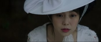 Movie still from “The Handmaiden” (2016), directed by Park Chan-wook – A person wearing a hat; Close Up shot, Low angle