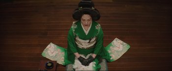 Movie still from “The Handmaiden” (2016), directed by Park Chan-wook – A geisha sitting on the ground wearing a green dress; Medium shot, High angle