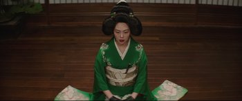 Movie still from “The Handmaiden” (2016), directed by Park Chan-wook – A geisha sitting on the ground wearing a green kimono; Medium shot, High angle