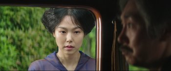 Movie still from “The Handmaiden” (2016), directed by Park Chan-wook – A young woman looking into a mirror in front of a train; Close Up shot, Over the shoulder angle