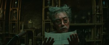 Movie still from “The Handmaiden” (2016), directed by Park Chan-wook – An older man with glasses is reading a paper; Close Up shot, Over the shoulder angle