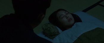 A woman laying on the ground in a dark room