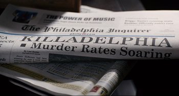 Movie still from “The Happening” (2008), directed by M. Night Shyamalan – A newspaper with the headline philadelphia murder rates soar; Extreme Close Up shot, High angle