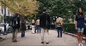Movie still from “The Happening” (2008), directed by M. Night Shyamalan – A group of people walking down a sidewalk; Wide shot, Over the shoulder angle
