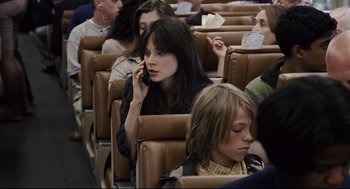 Movie still from “The Happening” (2008), directed by M. Night Shyamalan – A woman on a cell phone sitting on a train; Close Up shot, High angle
