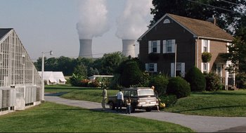 Movie still from “The Happening” (2008), directed by M. Night Shyamalan – Two people standing next to a truck in front of a house; Extreme Wide shot, Low angle