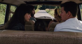 Movie still from “The Happening” (2008), directed by M. Night Shyamalan – A group of people sitting in the back of a car; Medium shot, High angle