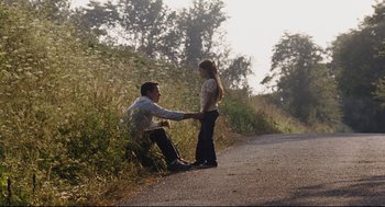 Movie still from “The Happening” (2008), directed by M. Night Shyamalan – A man and a young girl sitting on the side of a road; Wide shot, Low angle