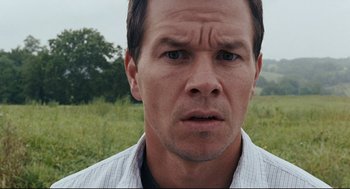 Movie still from “The Happening” (2008), directed by M. Night Shyamalan – A man's face in a grassy field; Close Up shot, Low angle