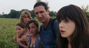 Movie still from “The Happening” (2008), directed by M. Night Shyamalan – A group of people standing next to each other in a field; Close Up shot, Low angle