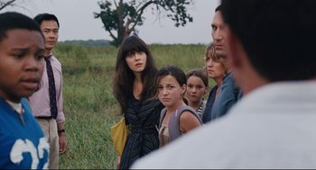 Movie still from “The Happening” (2008), directed by M. Night Shyamalan – A group of people standing in the grass; Close Up shot, Over the shoulder angle