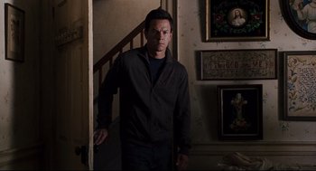 Movie still from “The Happening” (2008), directed by M. Night Shyamalan – A man standing in front of a staircase; Medium shot, Over the shoulder angle