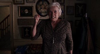 Movie still from “The Happening” (2008), directed by M. Night Shyamalan – An older woman is holding her fist in the air; Medium shot, Low angle