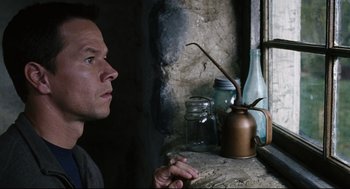 Movie still from “The Happening” (2008), directed by M. Night Shyamalan – A man sitting in front of a window looking at a plant; Close Up shot, Low angle