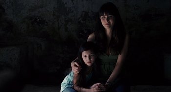 Movie still from “The Happening” (2008), directed by M. Night Shyamalan – A woman and a young girl sitting next to each other in a dark room; Close Up shot, High angle