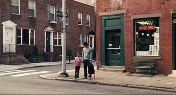 Movie still from “The Happening” (2008), directed by M. Night Shyamalan – A man and a child standing on a sidewalk; Wide shot, High angle