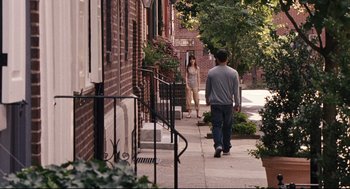 Movie still from “The Happening” (2008), directed by M. Night Shyamalan – A man and a woman walking down a sidewalk; Wide shot, High angle