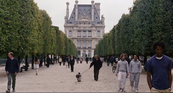 Movie still from “The Happening” (2008), directed by M. Night Shyamalan – A group of people walking a dog down a street; Wide shot, Over the shoulder angle