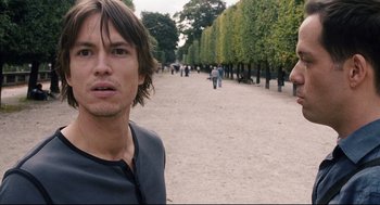 Movie still from “The Happening” (2008), directed by M. Night Shyamalan – A man standing on a dirt road near trees; Close Up shot, Over the shoulder angle