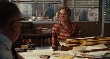 Movie still from “The Help” (2011), directed by Tate Taylor – A woman sitting at a desk in front of a pile of papers; Medium shot, Over the shoulder angle