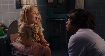 Movie still from “The Help” (2011), directed by Tate Taylor – A little girl sitting next to a woman in a room; Medium shot, Over the shoulder angle