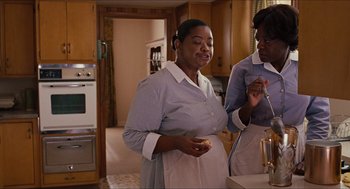 Movie still from “The Help” (2011), directed by Tate Taylor – Two women standing in a kitchen holding a spoon; Medium shot, High angle