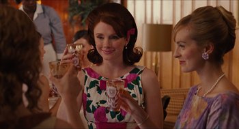 Movie still from “The Help” (2011), directed by Tate Taylor – A woman holding a glass in her hand and smiling; Medium shot, Over the shoulder angle