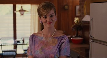 Movie still from “The Help” (2011), directed by Tate Taylor – A woman wearing a purple dress and a pearl necklace; Medium shot, Over the shoulder angle