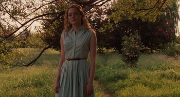 Movie still from “The Help” (2011), directed by Tate Taylor – A woman in a dress standing in the grass; Medium shot, Low angle