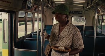 Movie still from “The Help” (2011), directed by Tate Taylor – A woman holding a tray of food on a bus; Medium shot, Over the shoulder angle