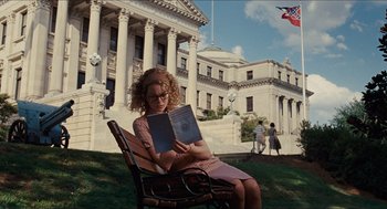 Movie still from “The Help” (2011), directed by Tate Taylor – A woman sitting on a park bench reading a book; Wide shot, Low angle