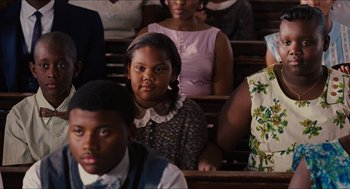 Movie still from “The Help” (2011), directed by Tate Taylor – A group of people sitting in a row of pews; Close Up shot, Over the shoulder angle
