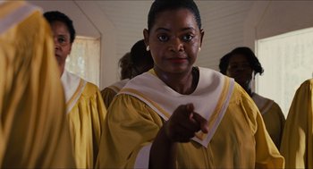Movie still from “The Help” (2011), directed by Tate Taylor – A woman in a yellow and white choir robe pointing; Close Up shot, Low angle
