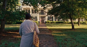 Movie still from “The Help” (2011), directed by Tate Taylor – A man walking down a brick path in front of a white house; Extreme Wide shot, Over the shoulder angle