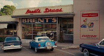 Movie still from “The Help” (2011), directed by Tate Taylor – An old car parked in front of a drug store; Extreme Wide shot, High angle