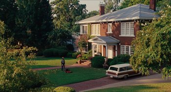 Movie still from “The Help” (2011), directed by Tate Taylor – A man is standing in front of a brick house; Extreme Wide shot, High angle