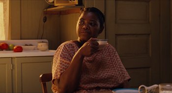 Movie still from “The Help” (2011), directed by Tate Taylor – A woman sitting in a chair holding a cup; Medium shot, Over the shoulder angle