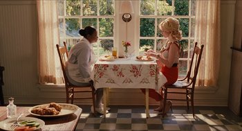 Movie still from “The Help” (2011), directed by Tate Taylor – Two women sitting at a table in front of a window; Wide shot, High angle