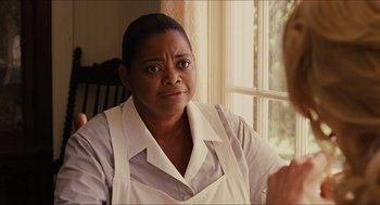 Movie still from “The Help” (2011), directed by Tate Taylor – A woman in a white shirt and a white shirt looking out a window; Close Up shot, Over the shoulder angle