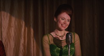 Movie still from “The Help” (2011), directed by Tate Taylor – A woman in a green dress holding a microphone; Medium shot, Low angle