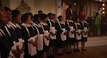 Movie still from “The Help” (2011), directed by Tate Taylor – A group of people standing next to each other in front of a microphone; Wide shot, Low angle