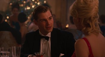 Movie still from “The Help” (2011), directed by Tate Taylor – A man in a tuxedo sitting at a table with a drink; Close Up shot, Over the shoulder angle