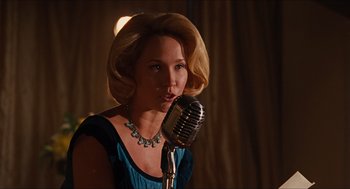 Movie still from “The Help” (2011), directed by Tate Taylor – A woman in a blue dress is singing into a microphone; Medium shot, Over the shoulder angle
