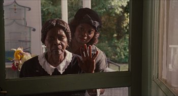 Movie still from “The Help” (2011), directed by Tate Taylor – Two women standing next to each other in front of a window; Medium shot, Over the shoulder angle