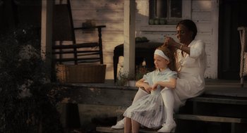 Movie still from “The Help” (2011), directed by Tate Taylor – A woman sitting next to a little girl on a porch; Medium shot, Over the shoulder angle