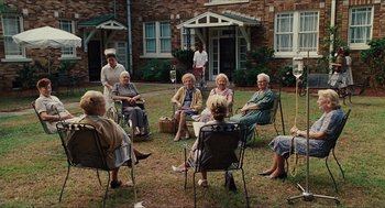 Movie still from “The Help” (2011), directed by Tate Taylor – A group of older women sitting in lawn chairs; Wide shot, High angle