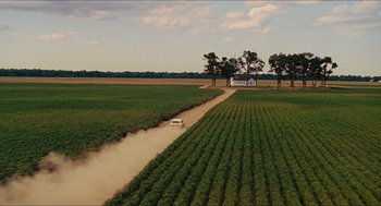 Movie still from “The Help” (2011), directed by Tate Taylor – An aerial view of a truck driving down a dirt road through a field; Extreme Wide shot, High angle